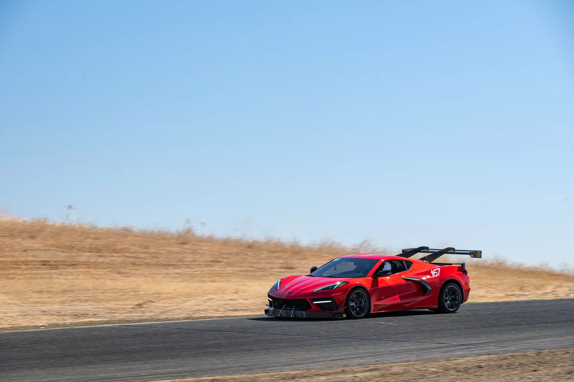Red C8 Corvette Stingray on track at speed